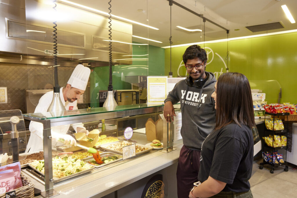 Students talking while waiting for their food in the cafeteria