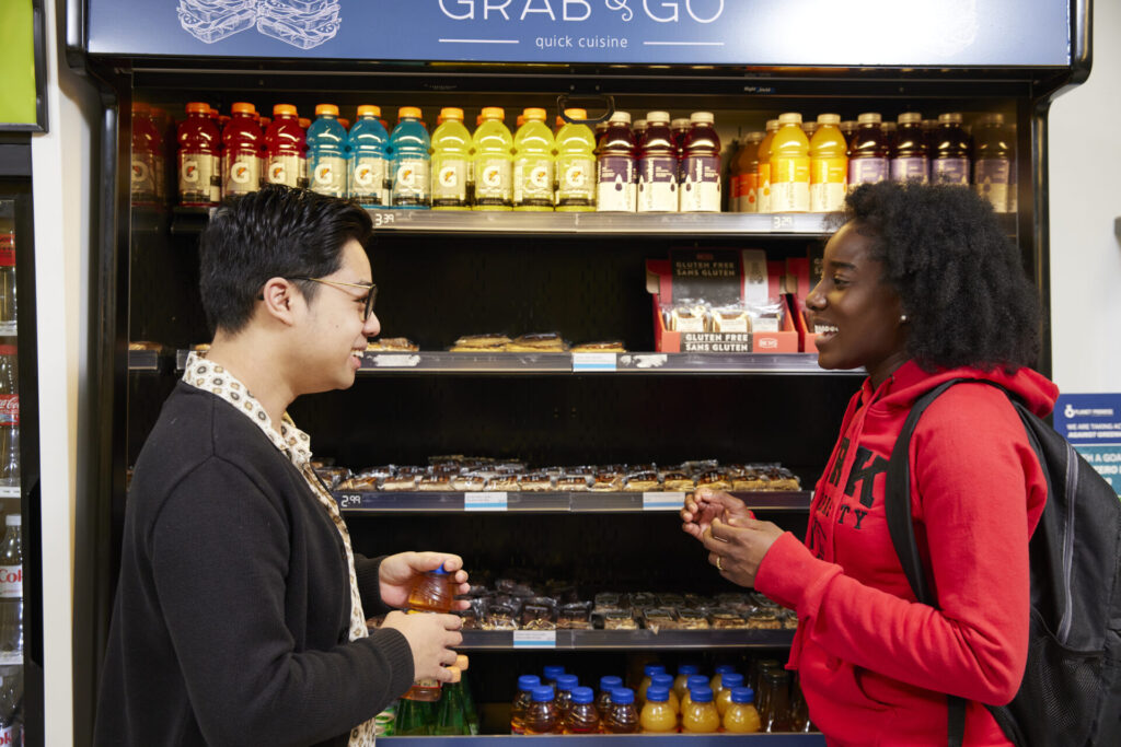 Students talking in front of a fridge