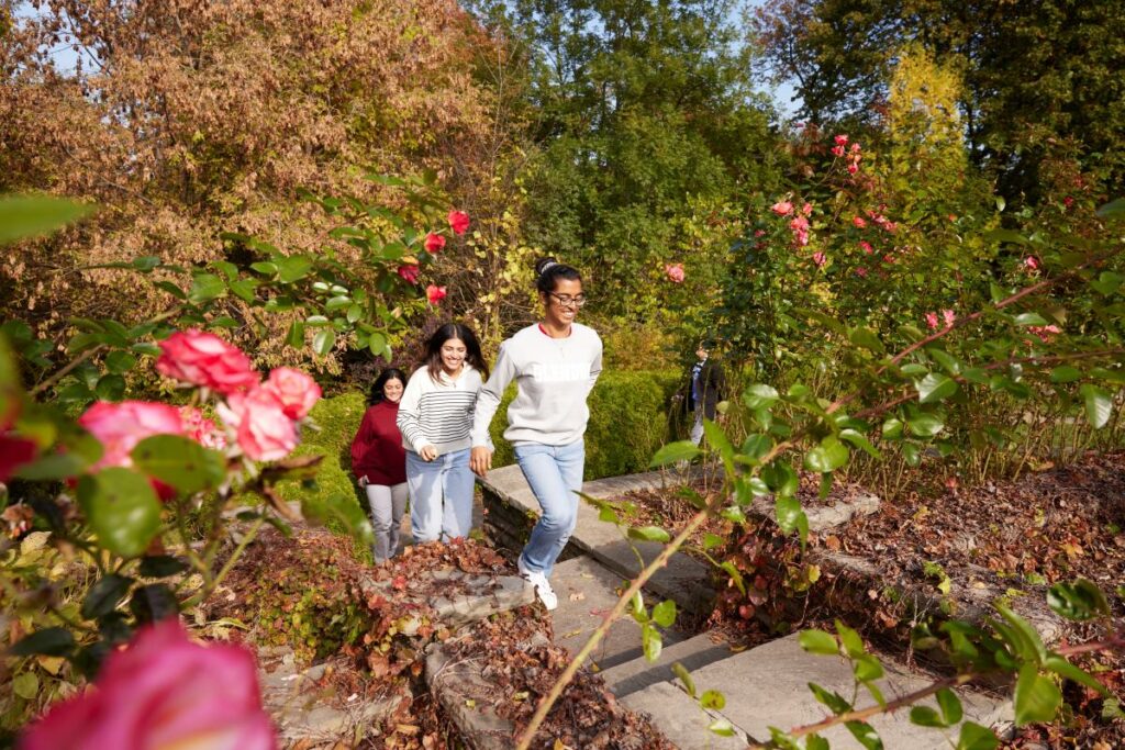 Girls running up the stairs in a rose garden