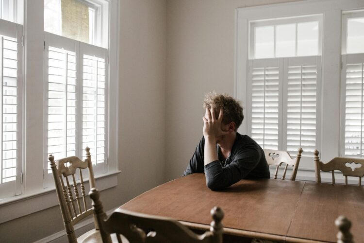 Man leaning on wooden table in dining room