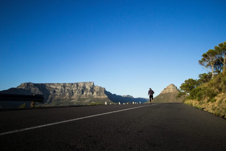 Man running during daytime with mountains in background