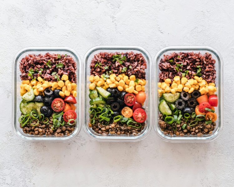 Photo of three identical lunch boxes with vegetables and rice