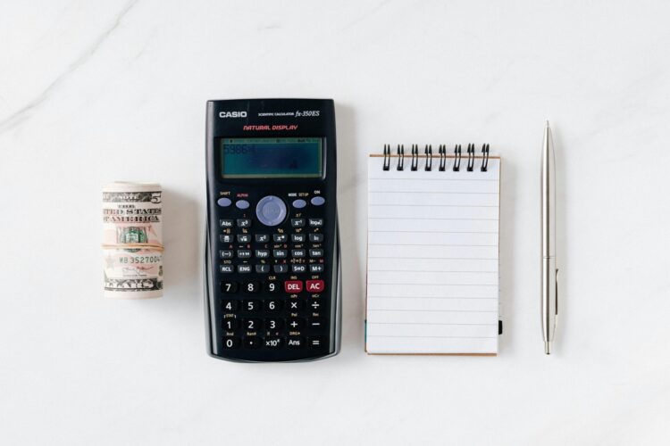 calculator with paper money and notebook with pen