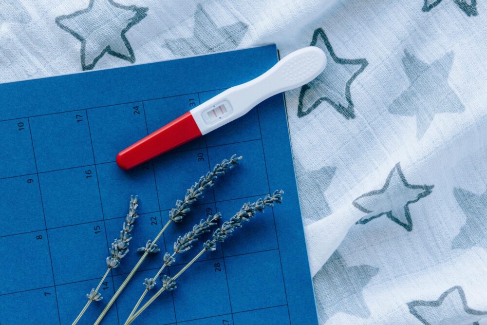 Pregnancy test and calendar resting on a cloth