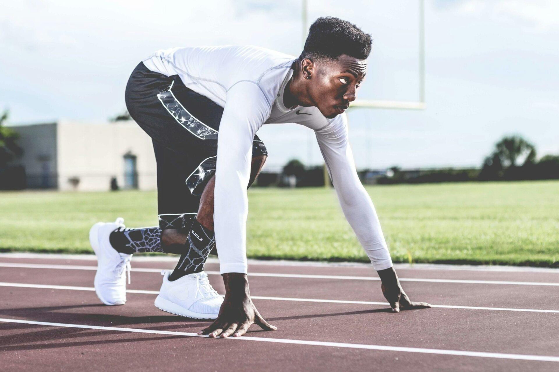 Man wearing white and black about to run on a race track