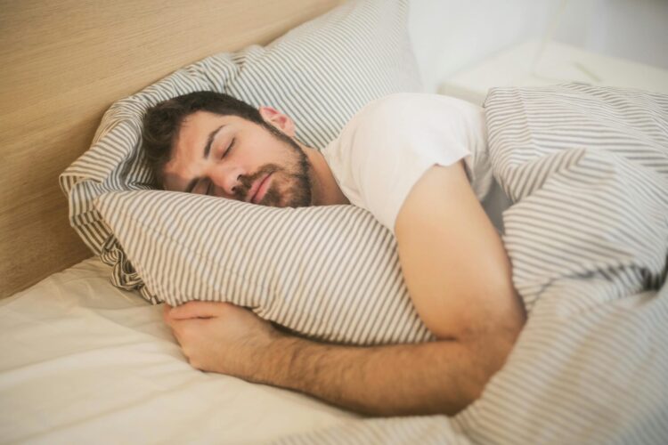 Man sleeping with blanket and pillow