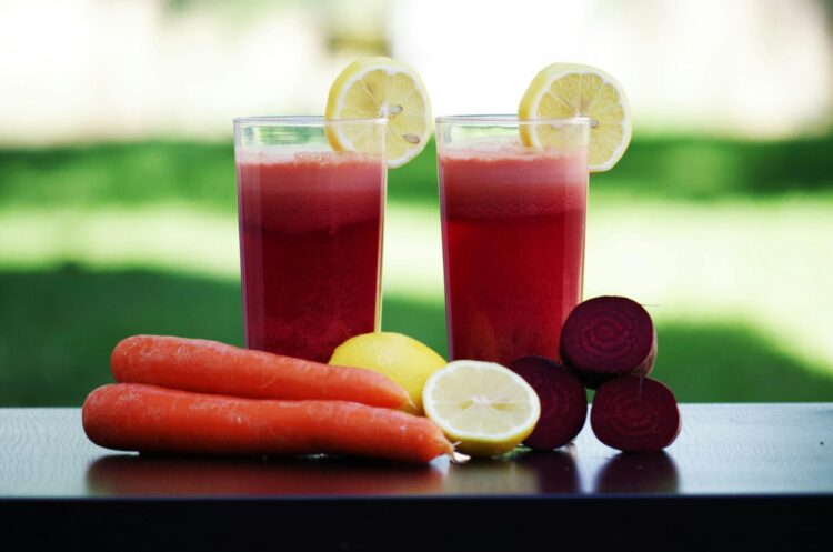 Carrot and lemon beside two smoothies