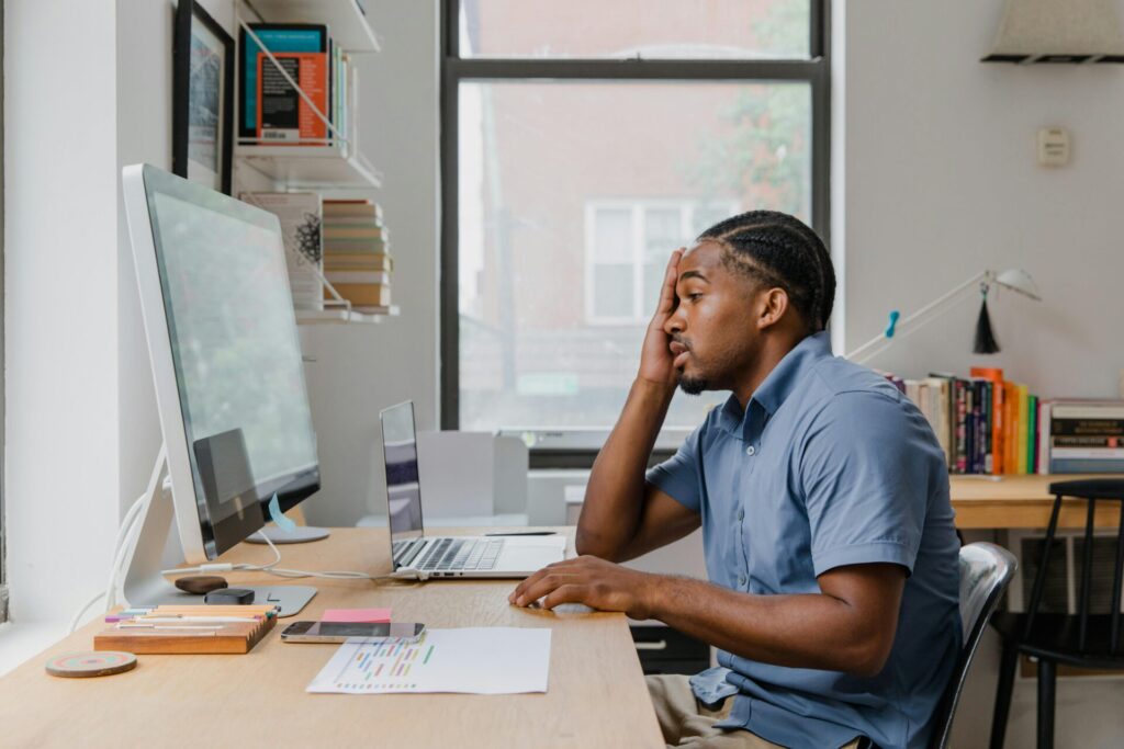 man working at desk with computers in office