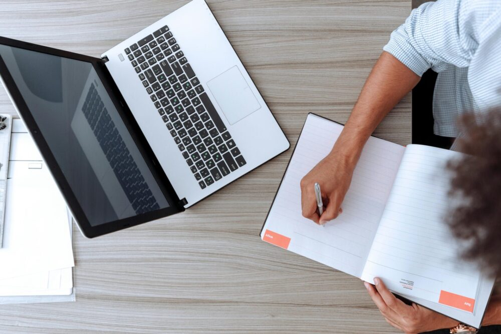 Person holding white paper on brown wooden table