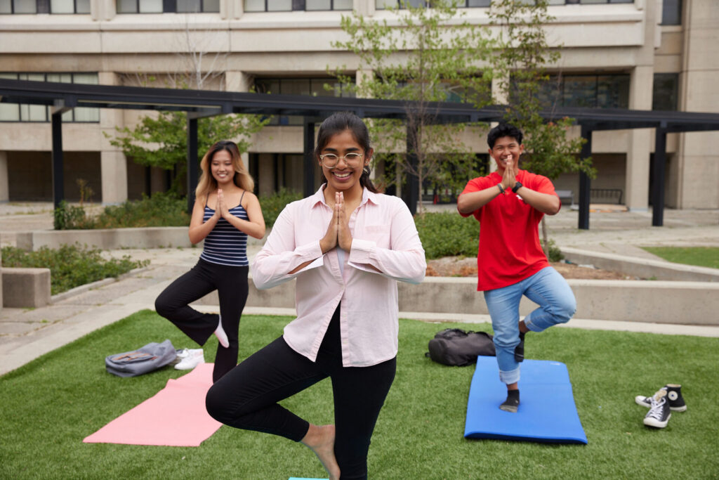 Students doing yoga on grass