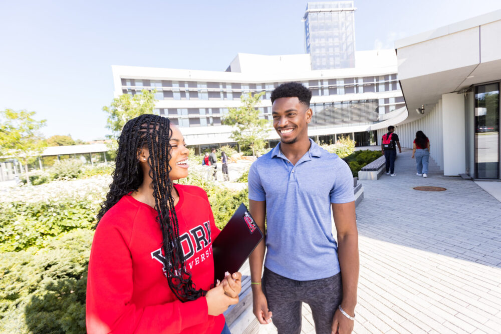 Two students standing and smiling