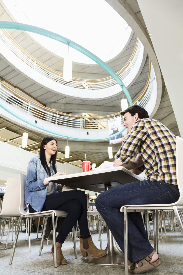 Two people sitting and eating in the food court