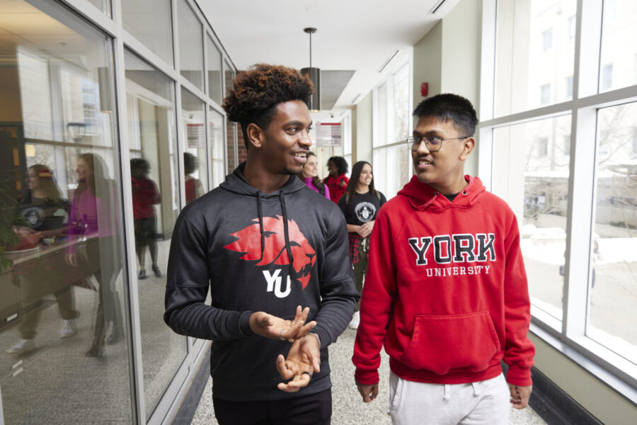 Two men walking and talking in the hallway