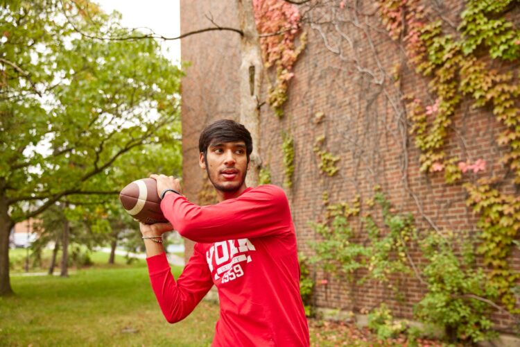 Man in red shirt throwing a football