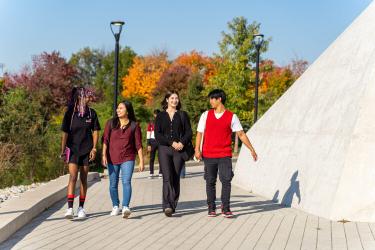 Students talking and walking by autumn trees