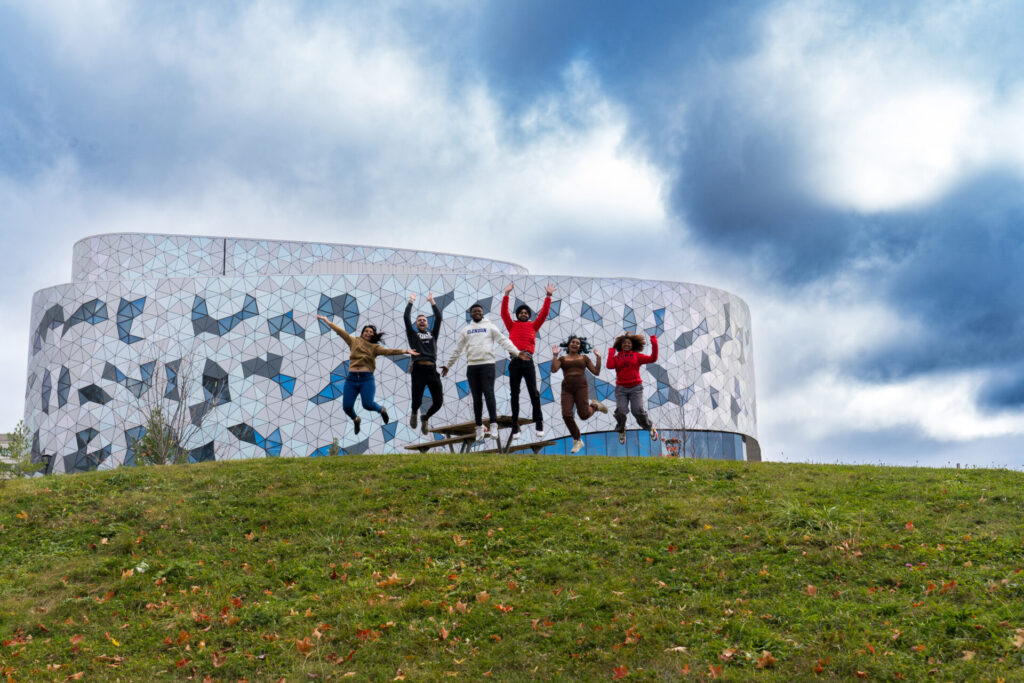 Students jumping in the air on a hill