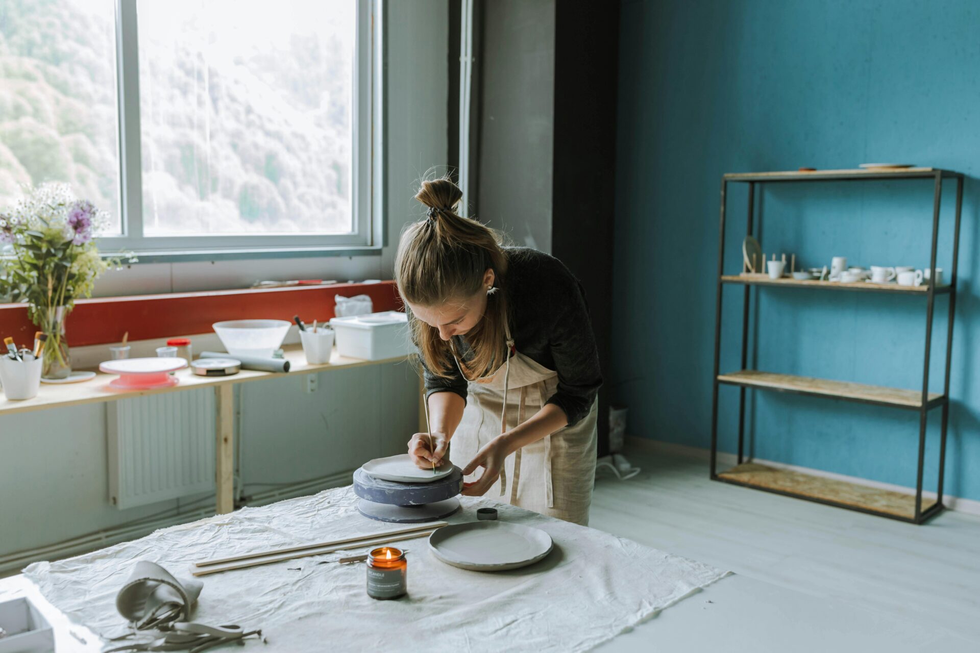 Woman painting on a clay plate