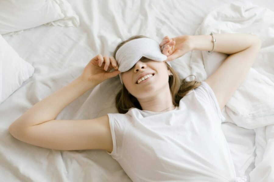 Woman in white shirt lying on bed