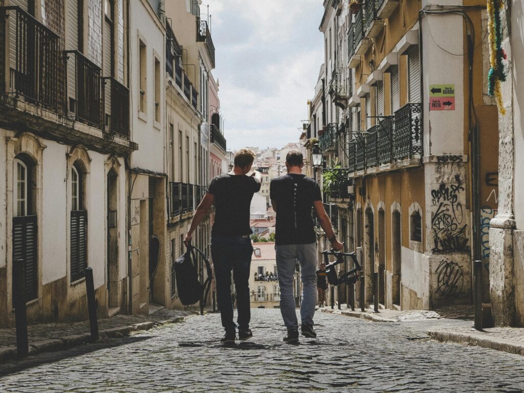 two man walking in between of buildings