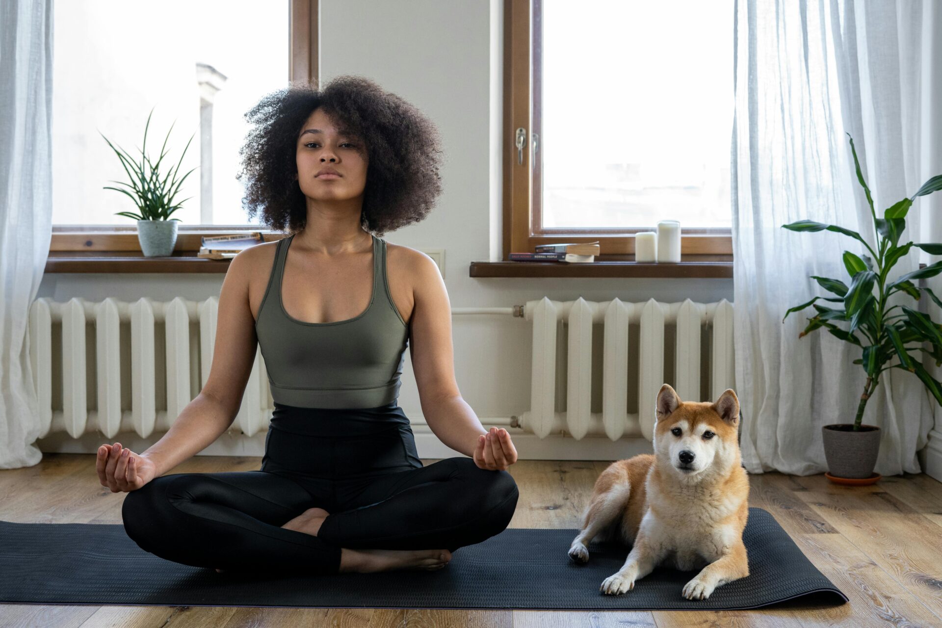 Woman and dog sitting on yoga mat