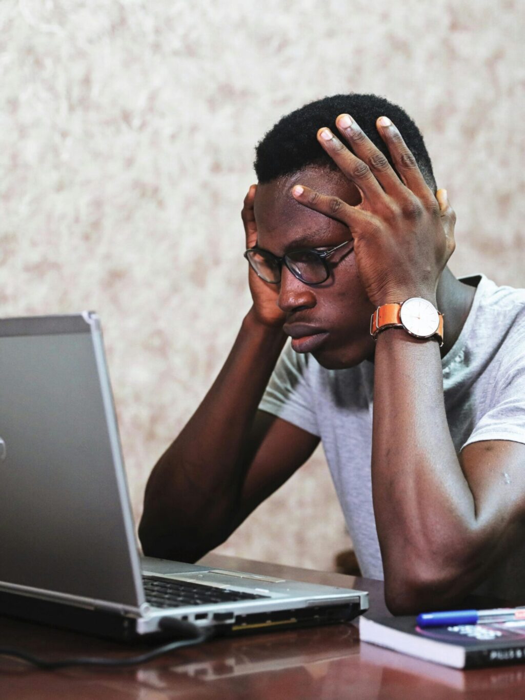 Man resting head on hands and looking at the laptop