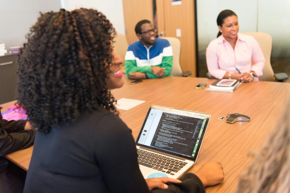 People sitting in front of a wooden table and having a meeting