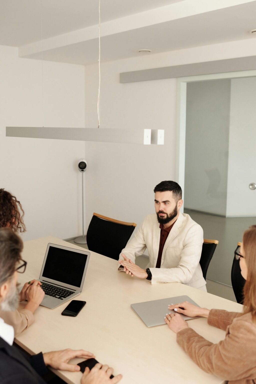 man in white suit jacket sitting having an interview