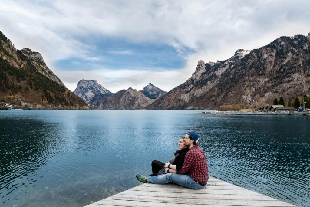 Man and woman sitting on a deck overlooking mountains