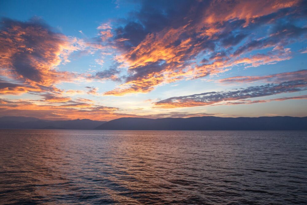 Body of water under cloudy sky during sunset