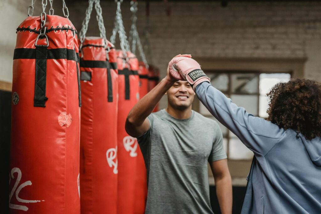 Trainer having high five with woman in boxing glove