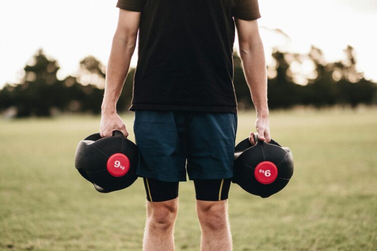 Person holding black dumbbells