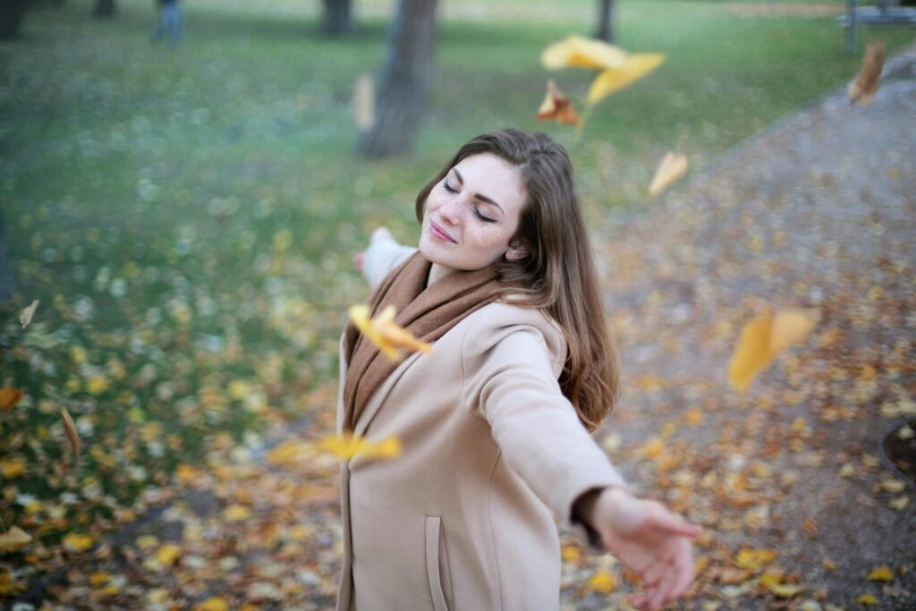 Woman open arms while closed eyes smiling