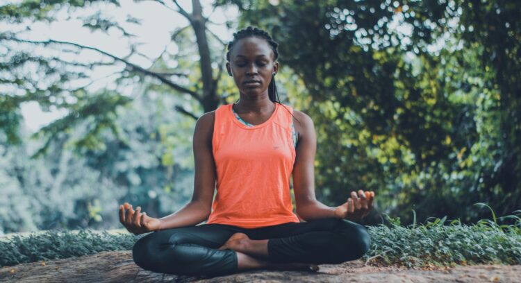 Woman meditating in the outdoors with eyes closed