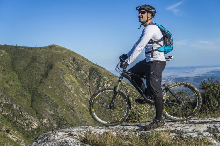 Man with white shirt riding bicycle on a mountain