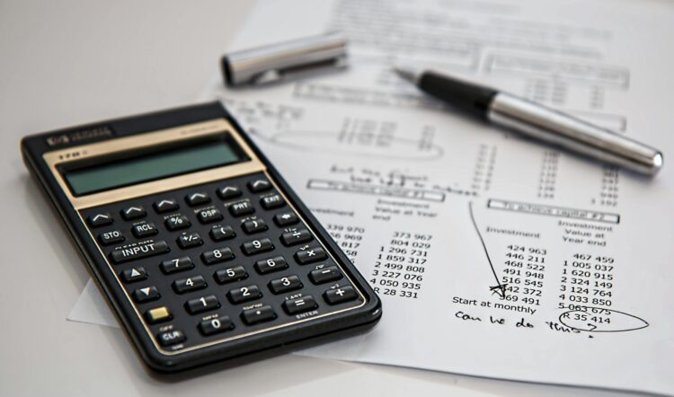 Calculator, document and pen on a white table