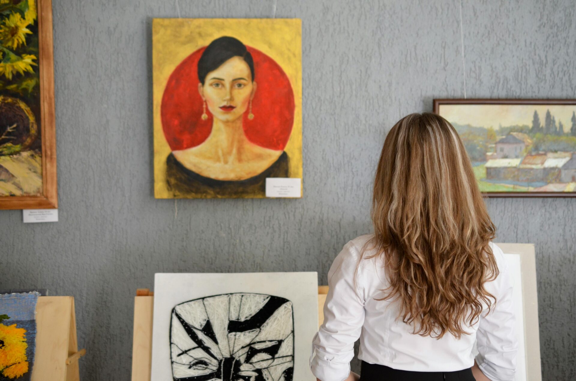 Women staring at paintings on the wall