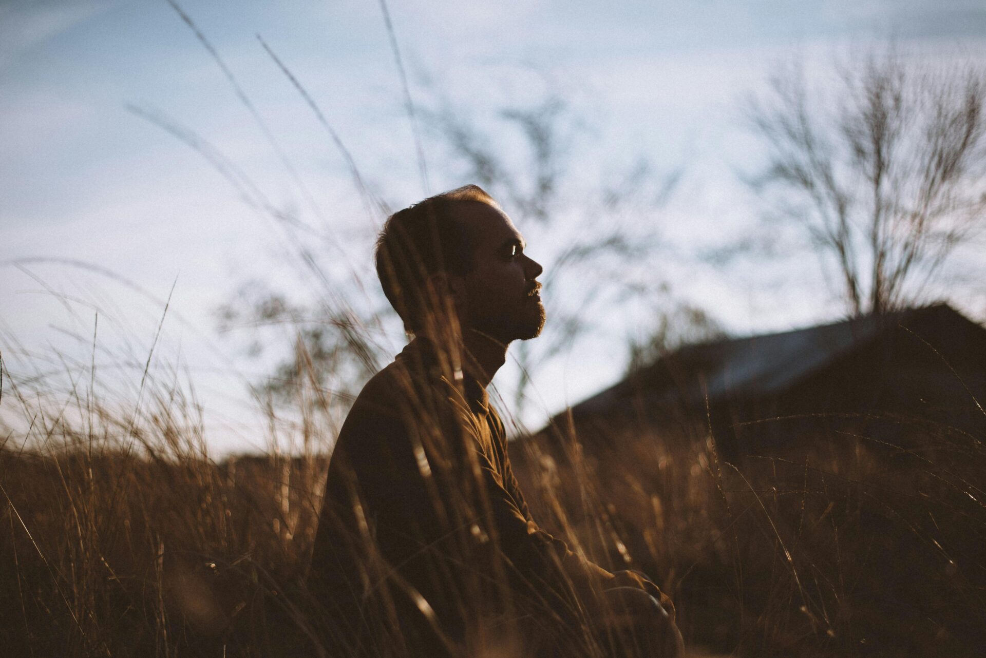 Man sitting down in a field being minfdul