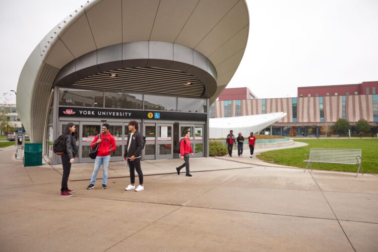 Students standing in front of a subway station entrance