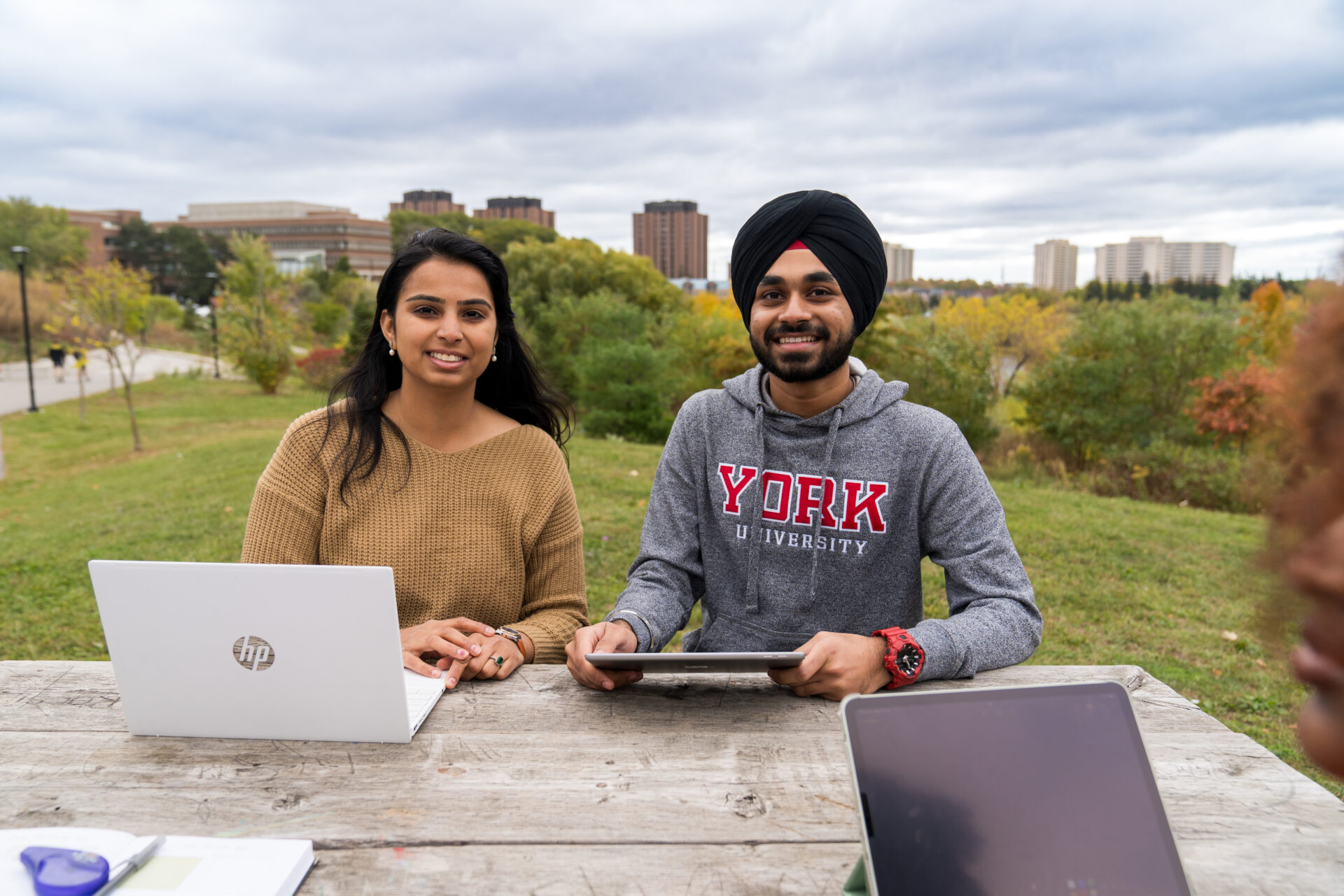 Students sitting at a bench smiling