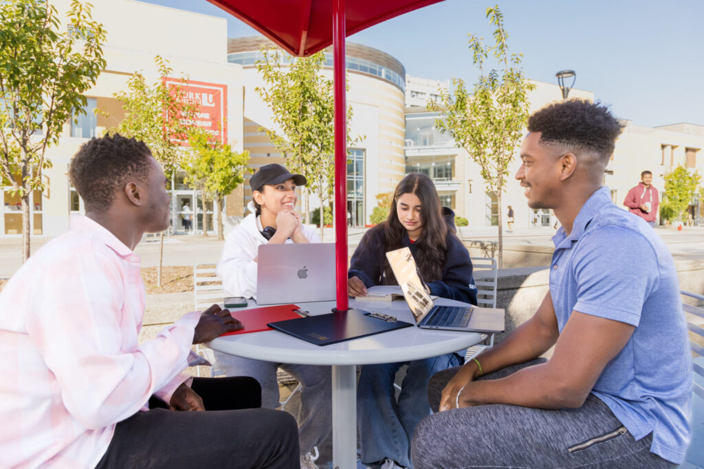 Students sitting at a patio table talking