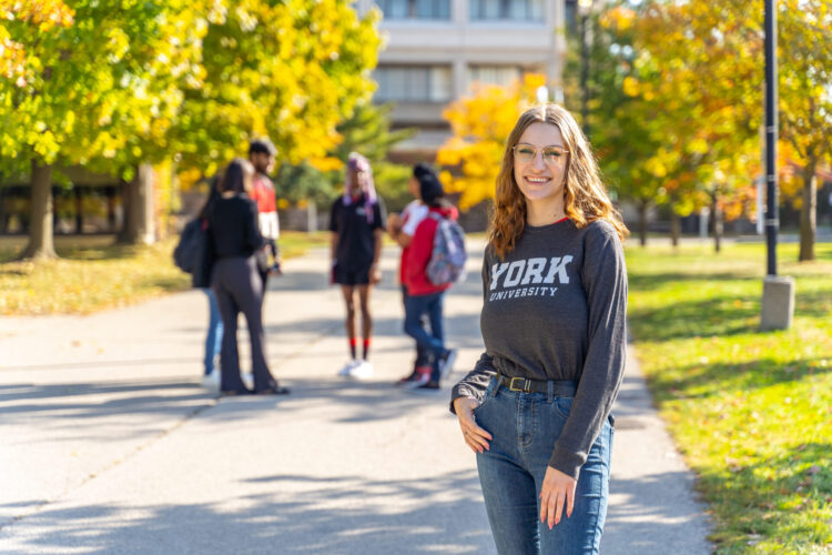 Woman standing with one hand in pocket.