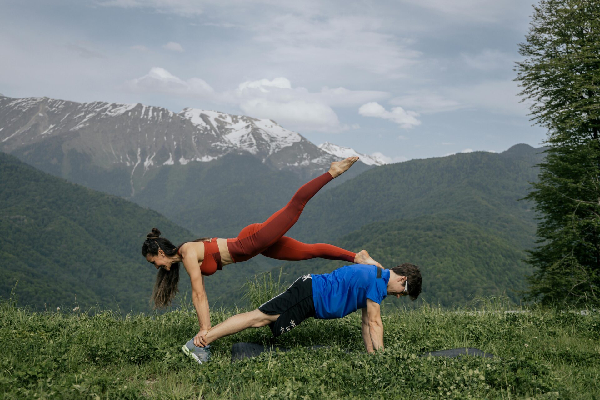 man and woman exercising on mountain-top