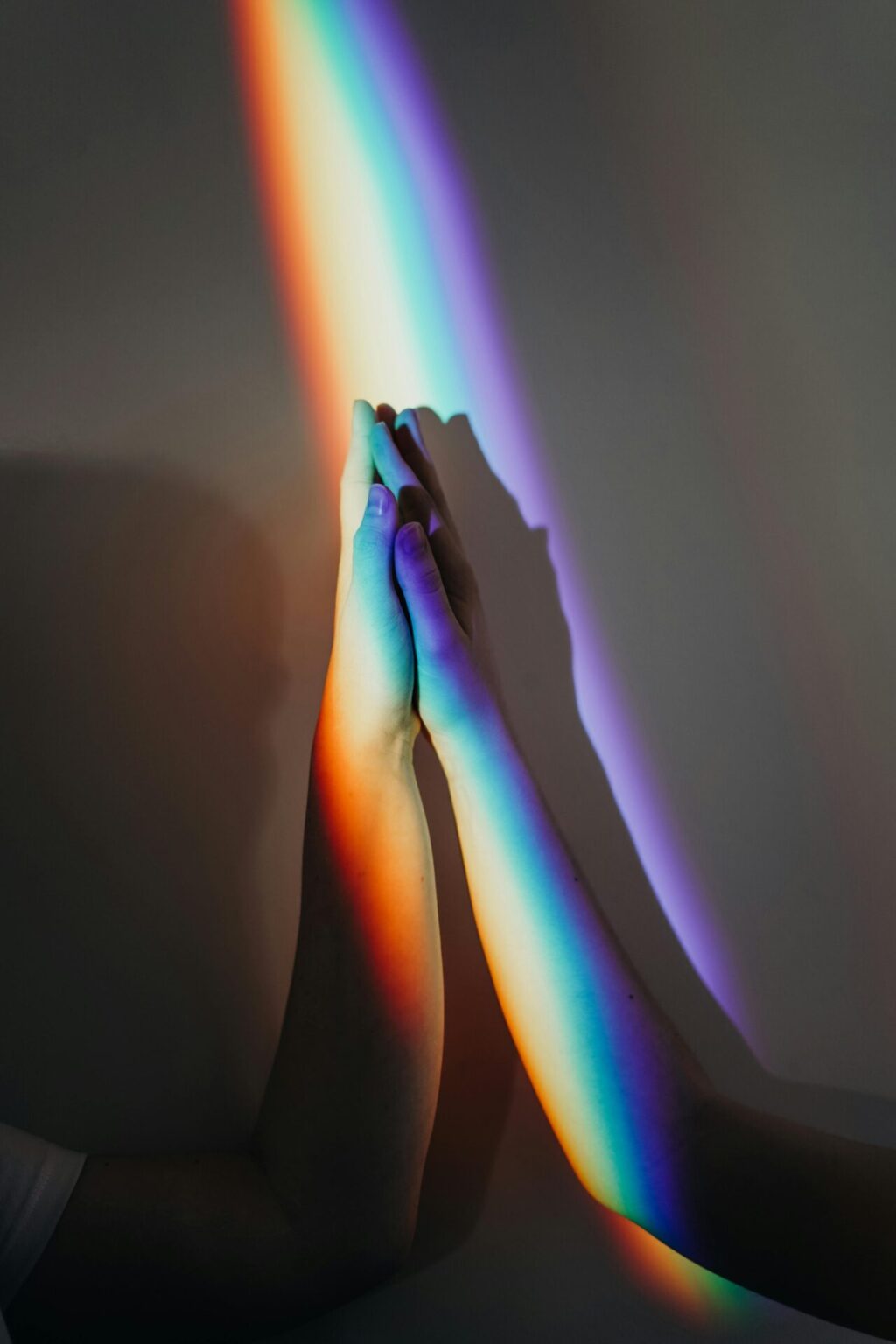 Two people holding hands with rainbow