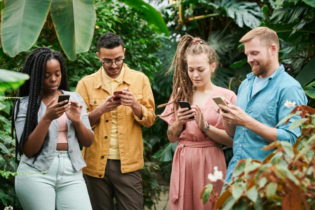 Group of people holding cellphones and looking down