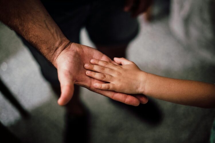 Photo of adult and child's hands together