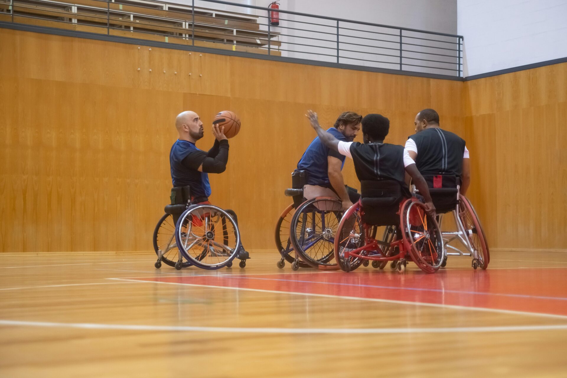 Men on a court playing basketball in wheelchairs