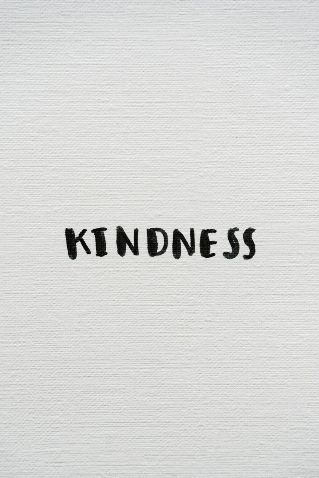 White surface with text "kindness"