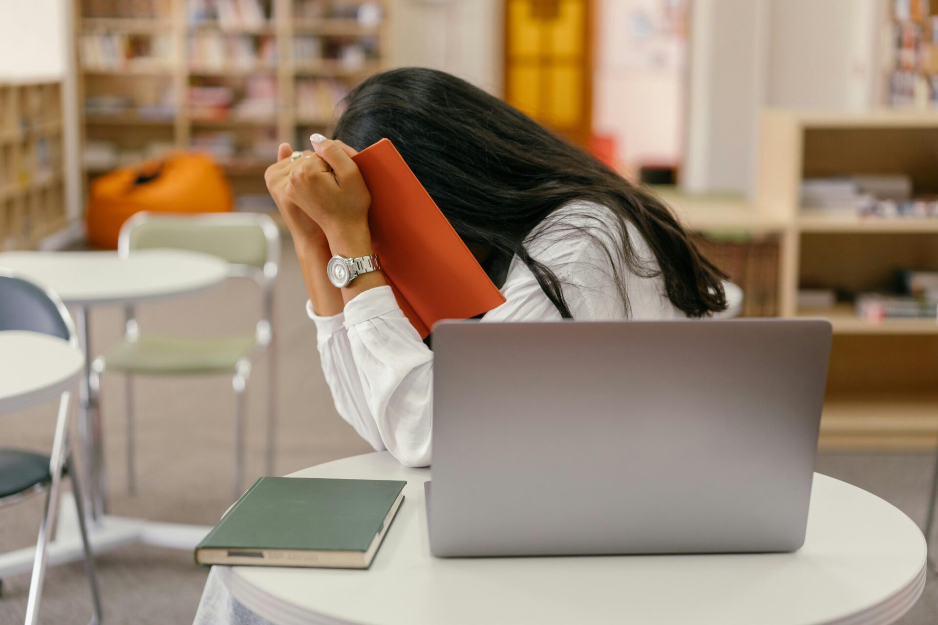 Women covering her face with a notebook