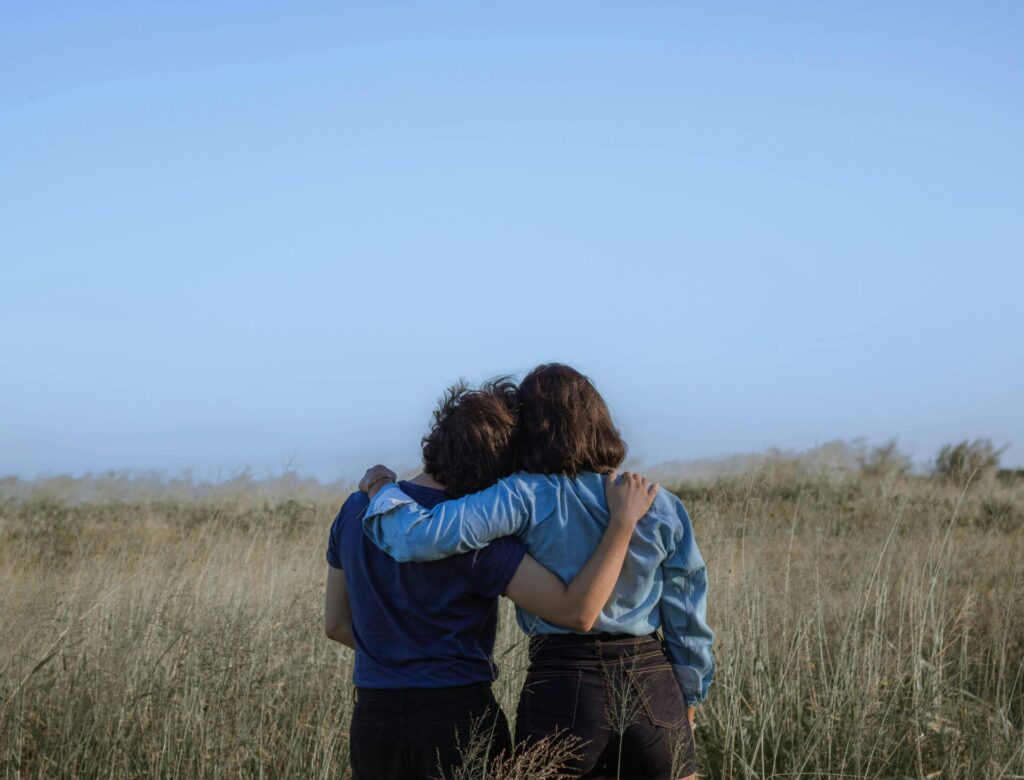 Two people hugging in a meadow