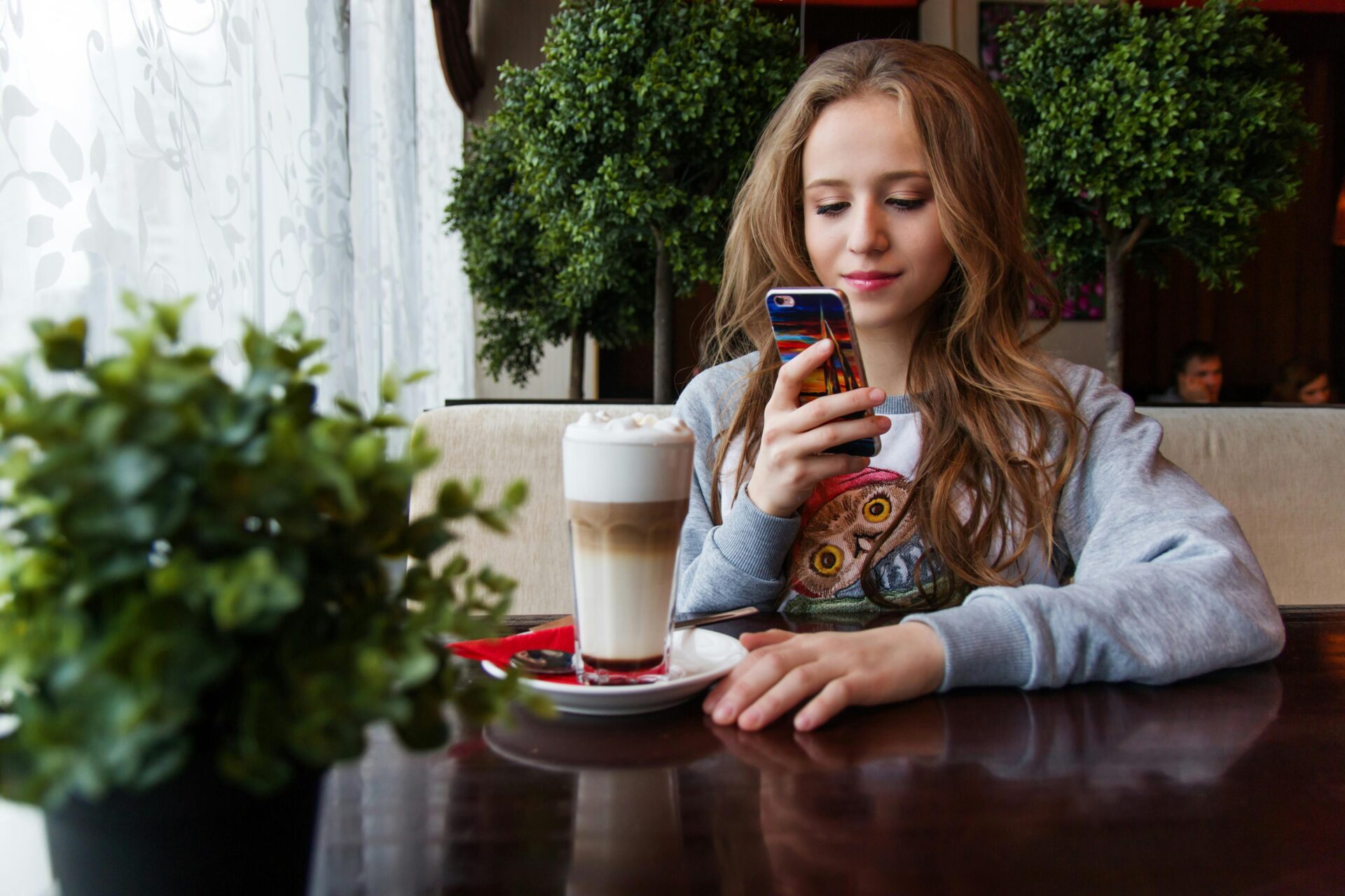 Woman photographing drink with smart phone